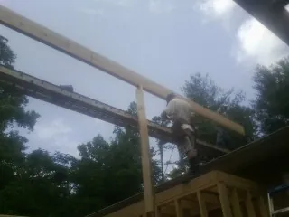 Carpenter setting a ridge beam over a new addition frame — Ice Dam Removal by Roofing Brothers in Orlinda