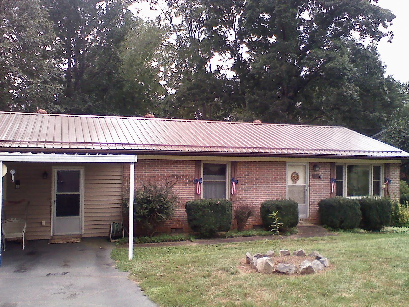 Bronze metal roof and carport on a brick ranch home — Roof Repair work by our crew in Orlinda